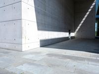 a empty room with a concrete wall and a red fire hydrant in it, as the sun shines on the stone floor