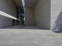 a empty room with a concrete wall and a red fire hydrant in it, as the sun shines on the stone floor