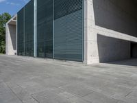 a empty room with a concrete wall and a red fire hydrant in it, as the sun shines on the stone floor