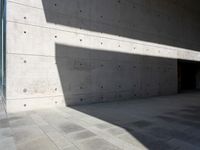 a empty room with a concrete wall and a red fire hydrant in it, as the sun shines on the stone floor