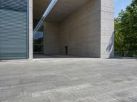 a empty room with a concrete wall and a red fire hydrant in it, as the sun shines on the stone floor