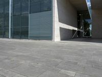 a empty room with a concrete wall and a red fire hydrant in it, as the sun shines on the stone floor