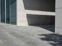a empty room with a concrete wall and a red fire hydrant in it, as the sun shines on the stone floor