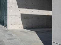 a empty room with a concrete wall and a red fire hydrant in it, as the sun shines on the stone floor
