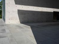 a empty room with a concrete wall and a red fire hydrant in it, as the sun shines on the stone floor