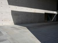 a empty room with a concrete wall and a red fire hydrant in it, as the sun shines on the stone floor