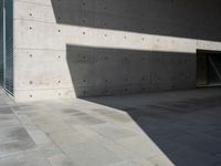 a empty room with a concrete wall and a red fire hydrant in it, as the sun shines on the stone floor