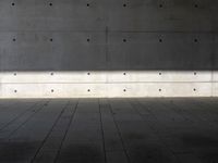 a empty room with a concrete wall and a red fire hydrant in it, as the sun shines on the stone floor