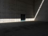 a empty room with a concrete wall and a red fire hydrant in it, as the sun shines on the stone floor