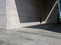 a empty room with a concrete wall and a red fire hydrant in it, as the sun shines on the stone floor