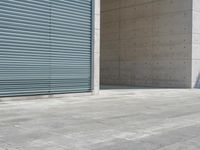 a empty room with a concrete wall and a red fire hydrant in it, as the sun shines on the stone floor