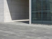 a empty room with a concrete wall and a red fire hydrant in it, as the sun shines on the stone floor