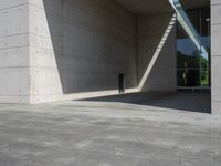 a empty room with a concrete wall and a red fire hydrant in it, as the sun shines on the stone floor