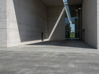 a empty room with a concrete wall and a red fire hydrant in it, as the sun shines on the stone floor