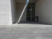 a empty room with a concrete wall and a red fire hydrant in it, as the sun shines on the stone floor