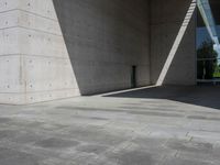 a empty room with a concrete wall and a red fire hydrant in it, as the sun shines on the stone floor