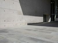 a empty room with a concrete wall and a red fire hydrant in it, as the sun shines on the stone floor