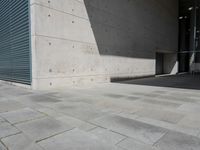 a empty room with a concrete wall and a red fire hydrant in it, as the sun shines on the stone floor