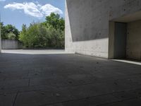 a empty room with a concrete wall and a red fire hydrant in it, as the sun shines on the stone floor