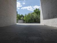 a empty room with a concrete wall and a red fire hydrant in it, as the sun shines on the stone floor