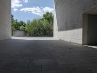 a empty room with a concrete wall and a red fire hydrant in it, as the sun shines on the stone floor