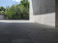 a empty room with a concrete wall and a red fire hydrant in it, as the sun shines on the stone floor