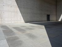 a empty room with a concrete wall and a red fire hydrant in it, as the sun shines on the stone floor