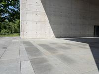 a empty room with a concrete wall and a red fire hydrant in it, as the sun shines on the stone floor