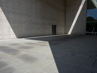 a empty room with a concrete wall and a red fire hydrant in it, as the sun shines on the stone floor