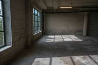 the sun is shining through the large windows of an empty room in a factory building