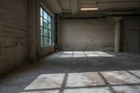 the sun is shining through the large windows of an empty room in a factory building