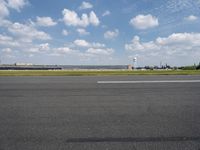 a airplane sitting on an empty runway in front of a building with a clock tower