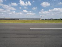 a airplane sitting on an empty runway in front of a building with a clock tower