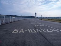 an empty runway with the word'no parking'written on it and the airport building in the background