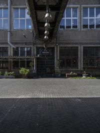 an empty sidewalk with benches in front of the buildings near by it and some windows