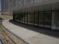 there is an empty sidewalk outside the building with some graffiti on it's side