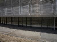 there is an empty sidewalk outside the building with some graffiti on it's side