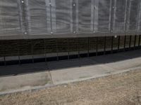 there is an empty sidewalk outside the building with some graffiti on it's side