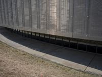 there is an empty sidewalk outside the building with some graffiti on it's side