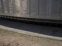 there is an empty sidewalk outside the building with some graffiti on it's side