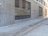 an empty sidewalk next to a building with a sky background next to it is a blue fire hydrant