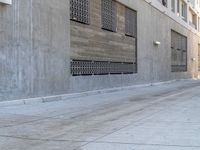 an empty sidewalk next to a building with a sky background next to it is a blue fire hydrant