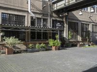 an image of a sidewalk outside of a restaurant that is very empty with windows and lots of plants