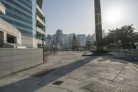 the sidewalk is empty with water and buildings in the background in hong kong, malaysia