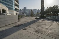 the sidewalk is empty with water and buildings in the background in hong kong, malaysia