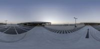 a view of an empty skate park taken from the inside with multiple angle mirrors to reveal the sun in the sky