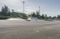 the skate park is empty and ready for people to ride on it, while others look on