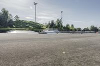 the skate park is empty and ready for people to ride on it, while others look on