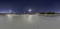 the skateboard park is empty for people to ride it at night time in the city