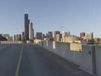 the view of a large city with skyscrapers is empty and sunny, as you can see from this bridge